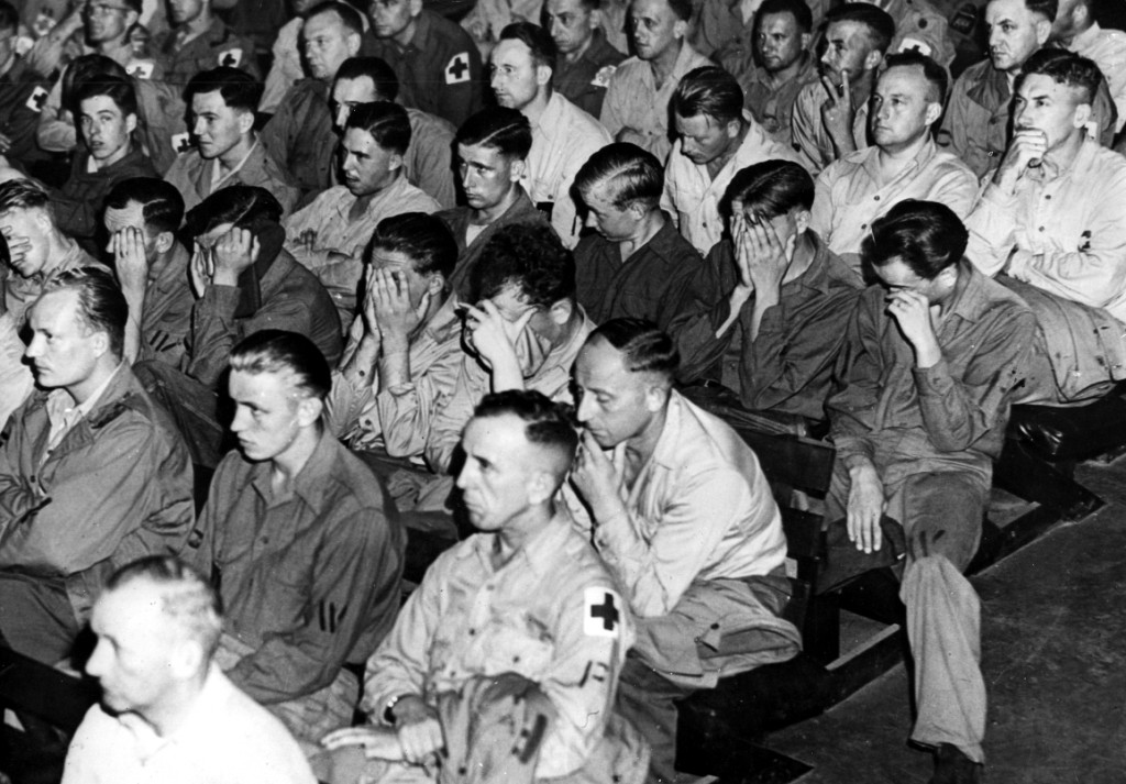 prisioneros de guerra alemanes viendo una película sobre los campos de concentración