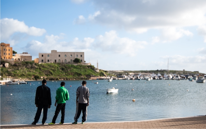 Lampedusa, entre el limbo y el edén 1 Migrantes eritreos contemplan las embarcaciones ancladas en la isla.