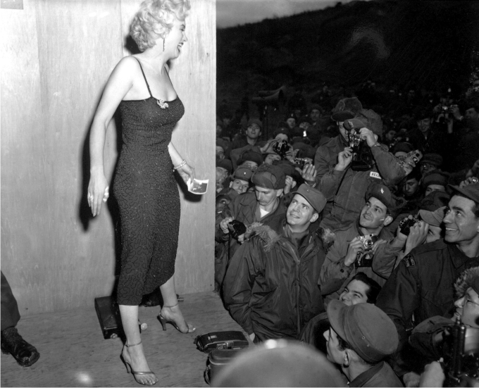 Marilyn Monroe posando para los fotógrafos después de una actuación en el área de la División de Infantería. EEUU, 17 febrero de 1954. (DP).  