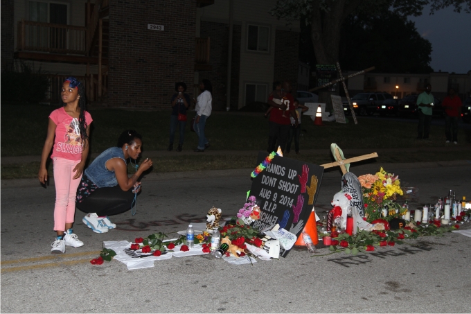 Una madre y su hija llevan llevan flores al lugar donde Michael Brown fue asesinado por la policía en Ferguson. Foto: Cordon Press.