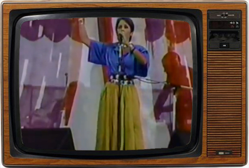 Momento de huir: Joan Baez cantando a capella (imagen: NBC).