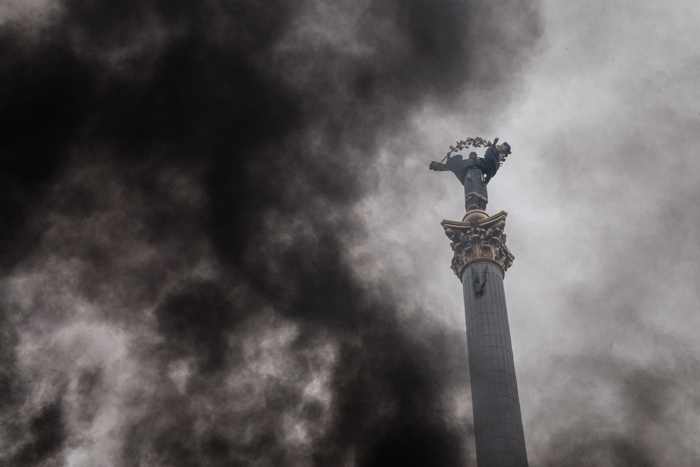 Estatua del Arcángel MIguel, que preside la Plaza de la Independencia de Kiev, entre humo, Magnífica fotografía de Mikhail Palinchak que simboliza a la perfección el caos ucraniano. (Foto: Corbis)