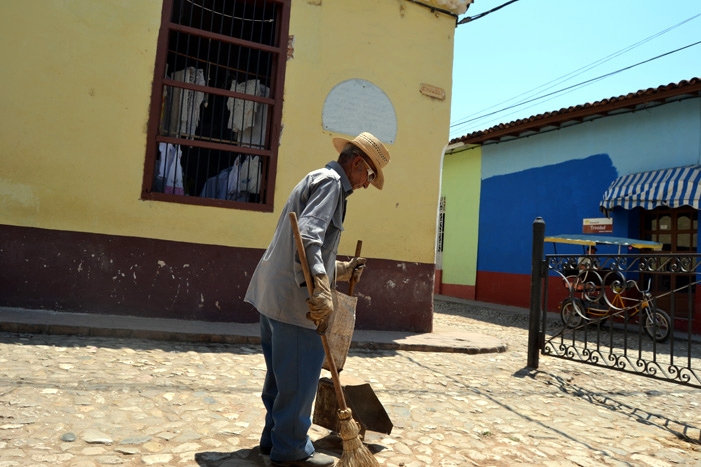 Un barrendero de avanzada edad en el centro de la ciudad de Trinidad.