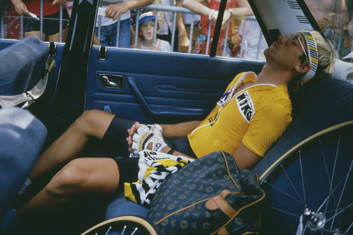 Laurent Fignon descansa en el coche de equipo ante la mirada curiosa de un niño del público (foto: Corbis)