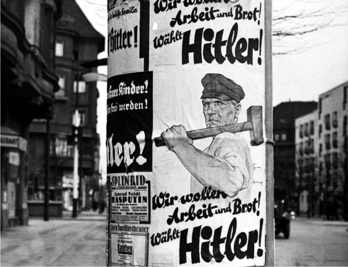 Cartel en una calle berlinesa en 1932, «Nosotros queremos trabajo y pan, vota por Hitler». Foto: Corbis.