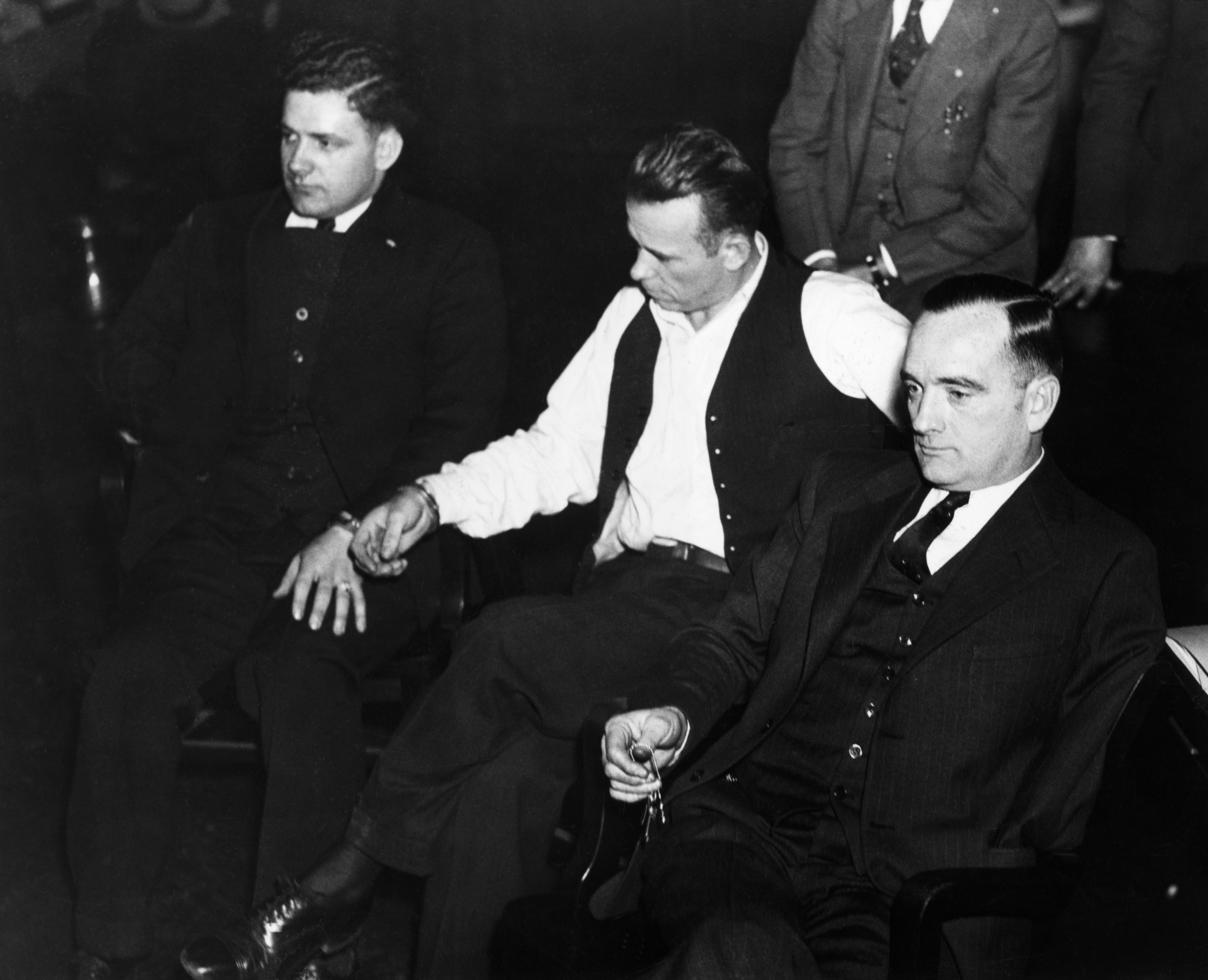ca.1933, Indiana, USA --- Original caption: IN-John Dillinger, notorius criminal in Indiana court, manacled to Sheriff Holley. At right is attorney Joseph Ryan. Photograph. --- Image by © Corbis