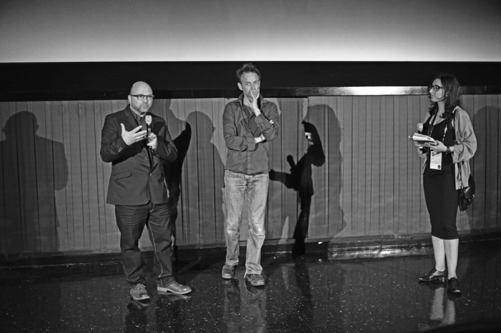 Andrew Feinstein (derecha), Johan Grimonprez (centro) y un batiburrillo de sombras (fondo) en la presentación de Shadow World.