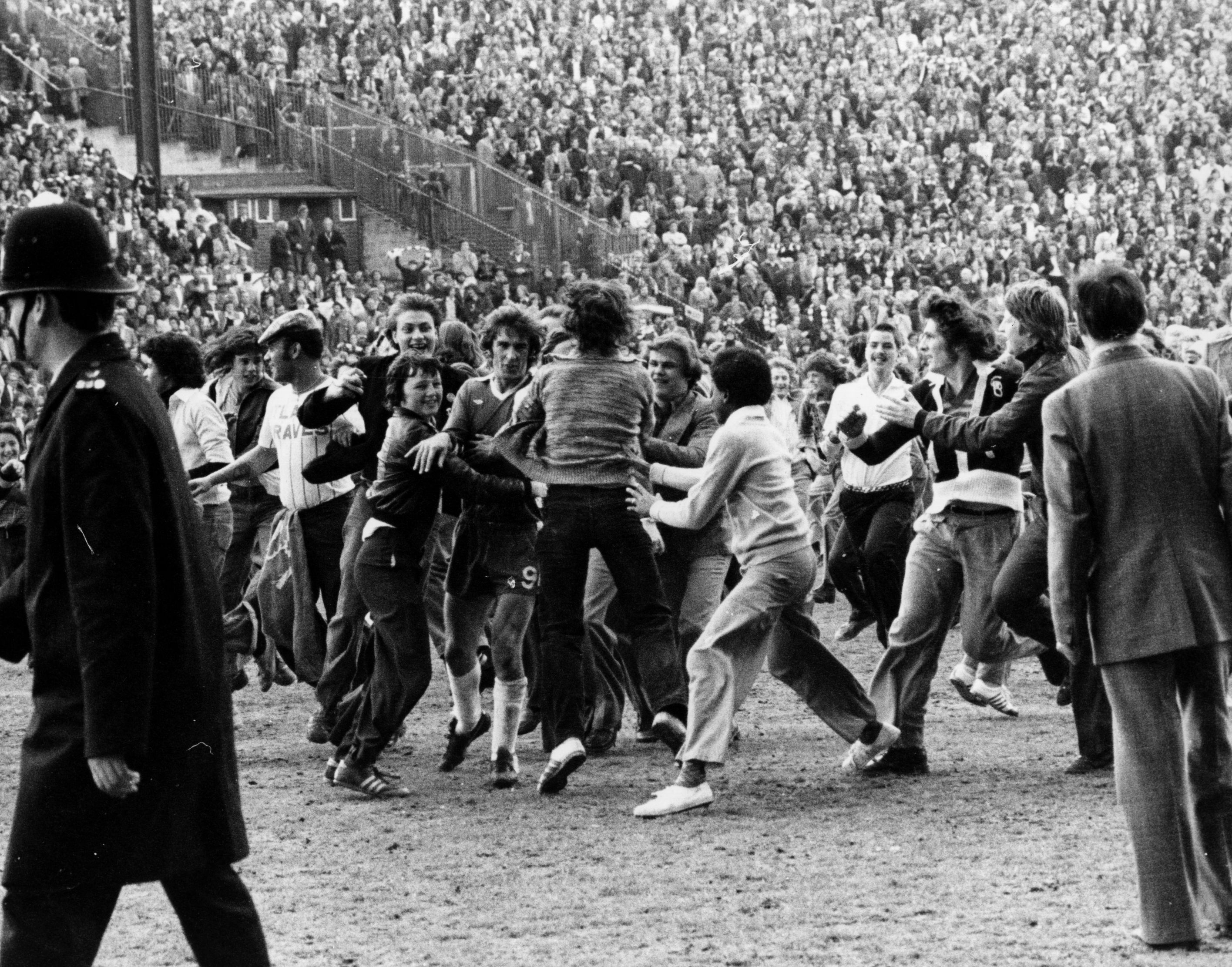 circa 1975: Sheffield United fans mob Steve Finneston as he tries to leave the football pitch. (Photo by Hulton Archive/Getty Images)