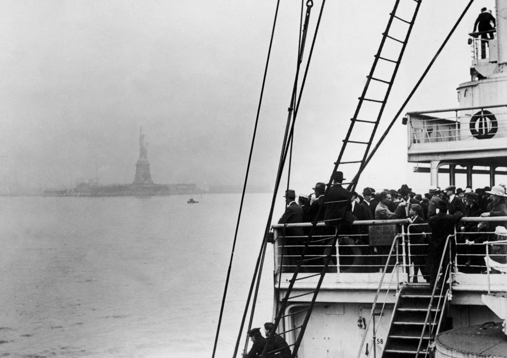 Immigrants view the Statue of Liberty while entering New York harbor aboard an ocean liner en route to Ellis Island, New York City, 1910s. (Photo by Edwin Levick/Getty Images)