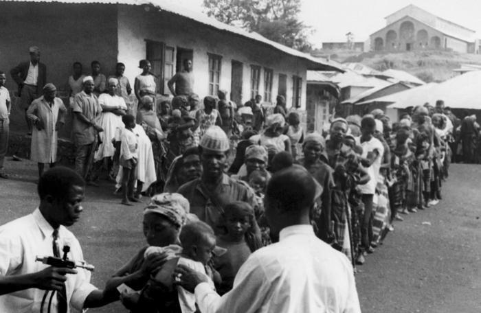 Captured in the tribal region of West Cameroon known as Banso, this historic photograph depicted the line of villagers awaiting their smallpox and measles vaccination during the country's participation in the Worldwide efforts to erradicate, and control these diseases during the 1960's.
