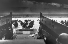 06 Jun 1944, France --- On D-Day, June 6, 1944, a landing craft just vacated by invasion troops points towards a fortified beach on the Normandy Coast. American soldiers wade to shore fighting heavy machine gun fire. --- Image by © CORBIS