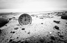 Clock on the beach. Time and business concept. Vintage retro picture.