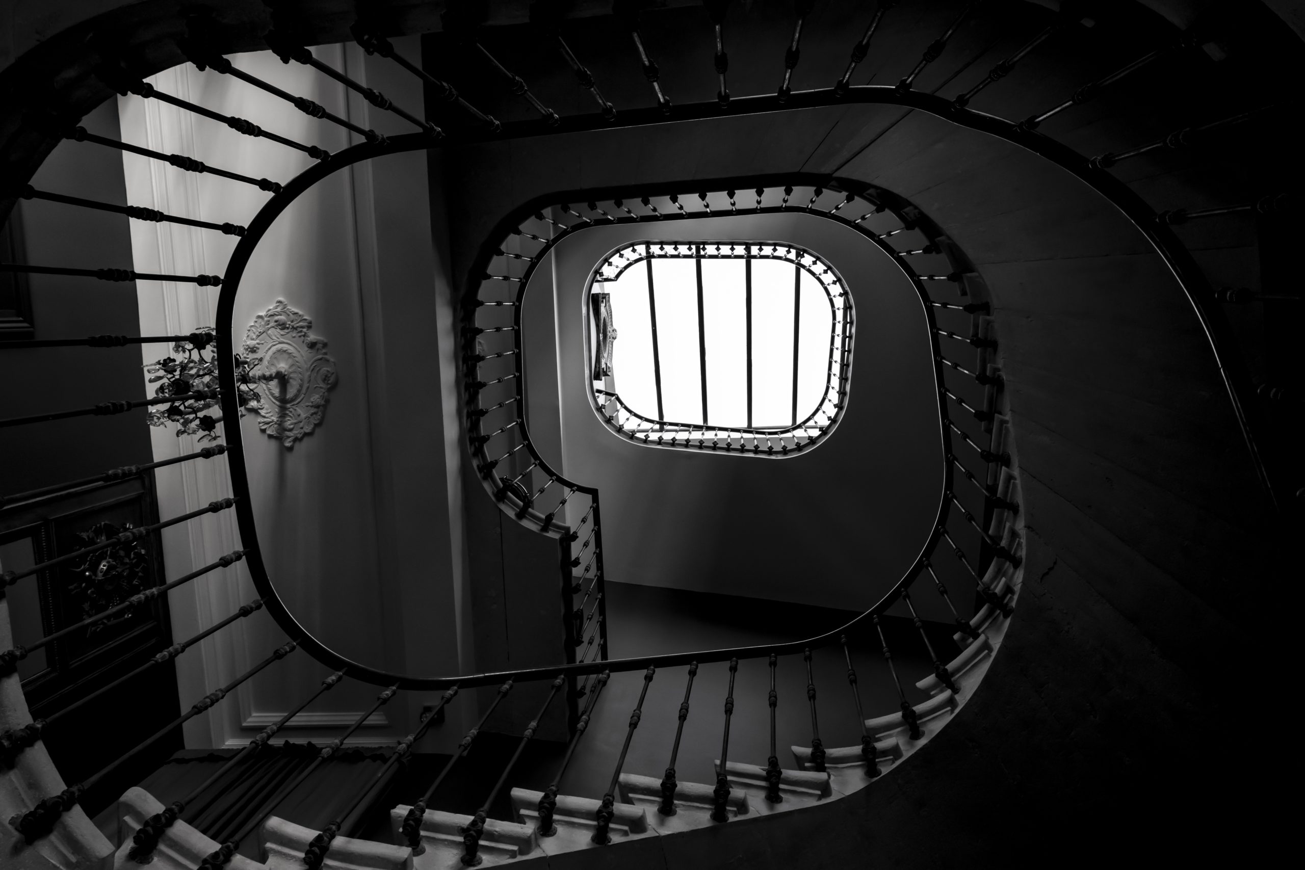 Greyscale shot of the spiral staircase of a building