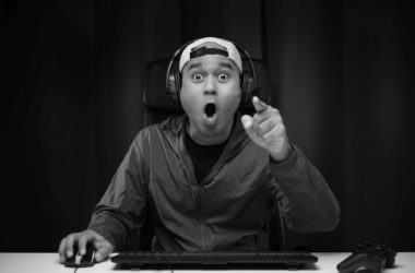 excited shocked face asian gamer with headphone playing computer pc video game online sitting living room indian professional gamer streaming social playing game very fun
