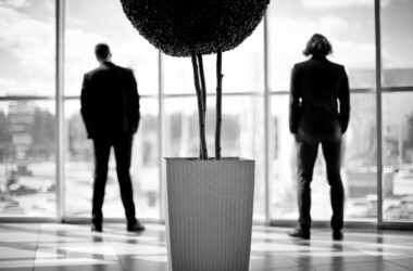 companeros de trabajo de pie junto las ventanas