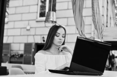 portrait strong independent successful businesswoman wearing smart casual clothing glasses working laptop cafe black white photo