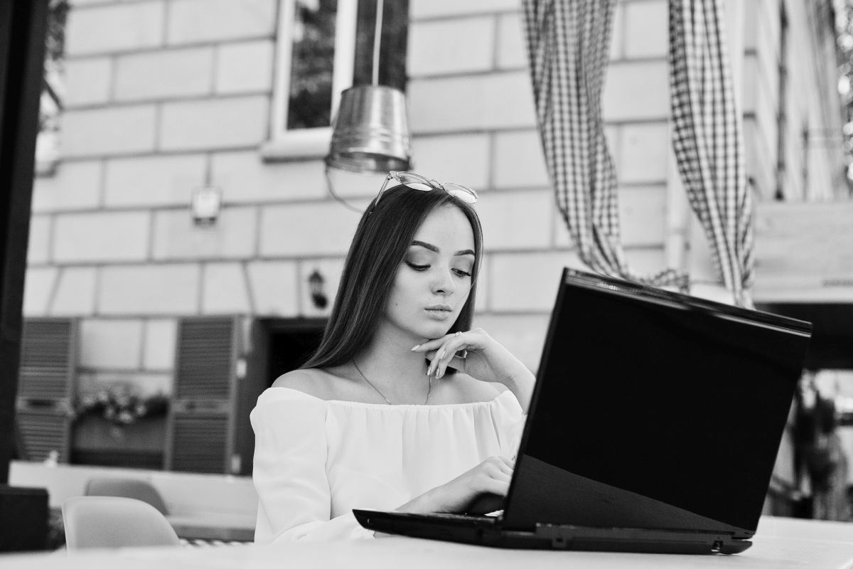 Cómo comprobar si un operador de un casino online es legal 1 portrait strong independent successful businesswoman wearing smart casual clothing glasses working laptop cafe black white photo
