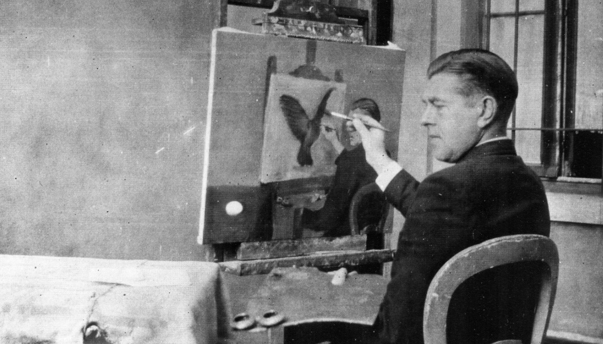 Fotografia de Rene Magritte pintando La clarividencia 1936