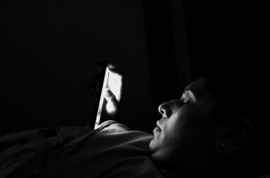 young woman using mobile phone darkroom