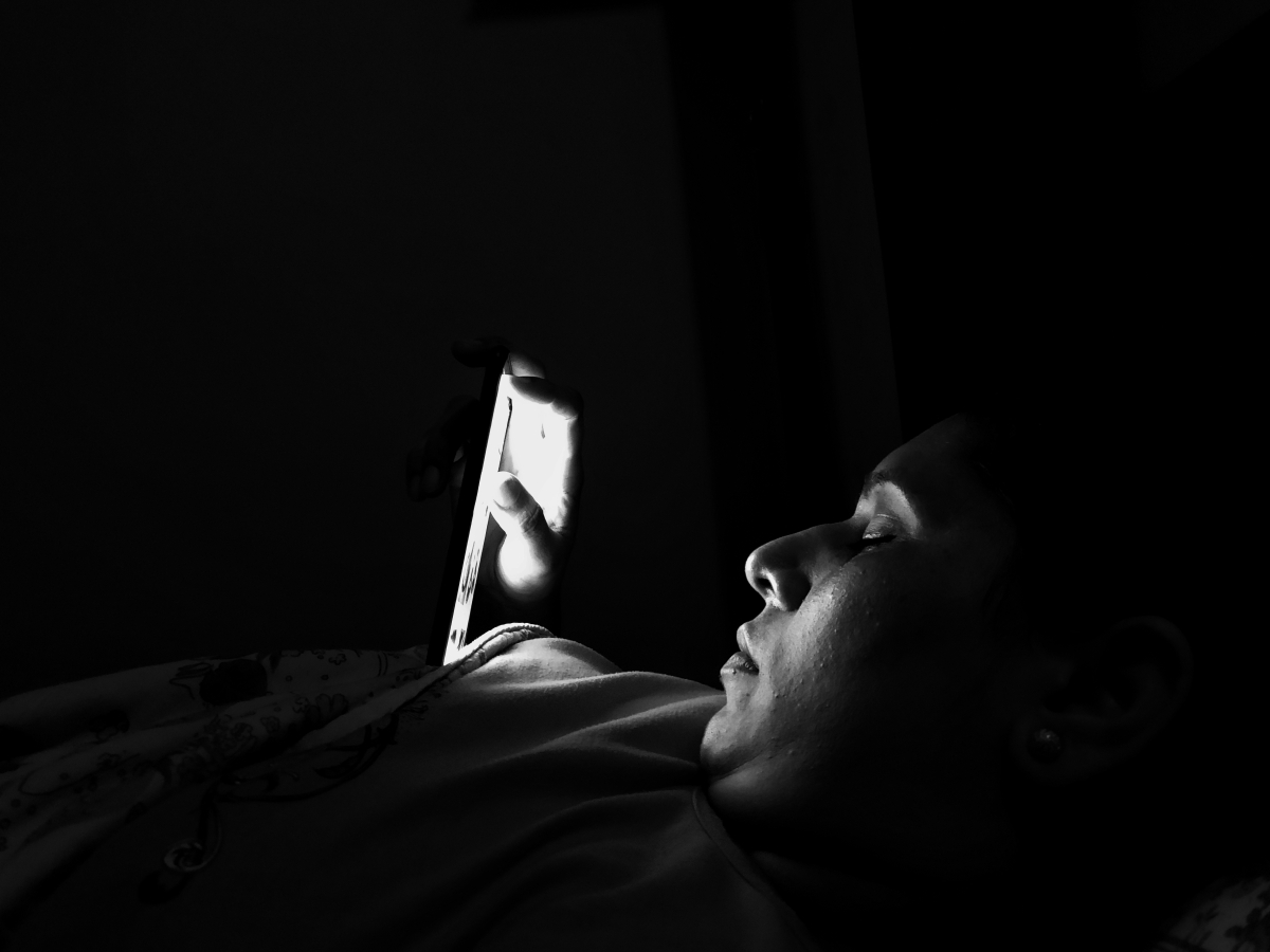 young woman using mobile phone darkroom